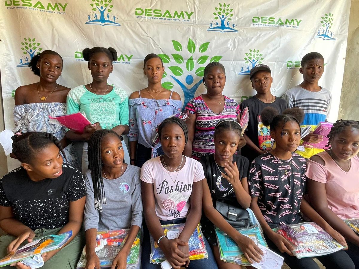 Group of DESAMY youth participants holding school supply kits